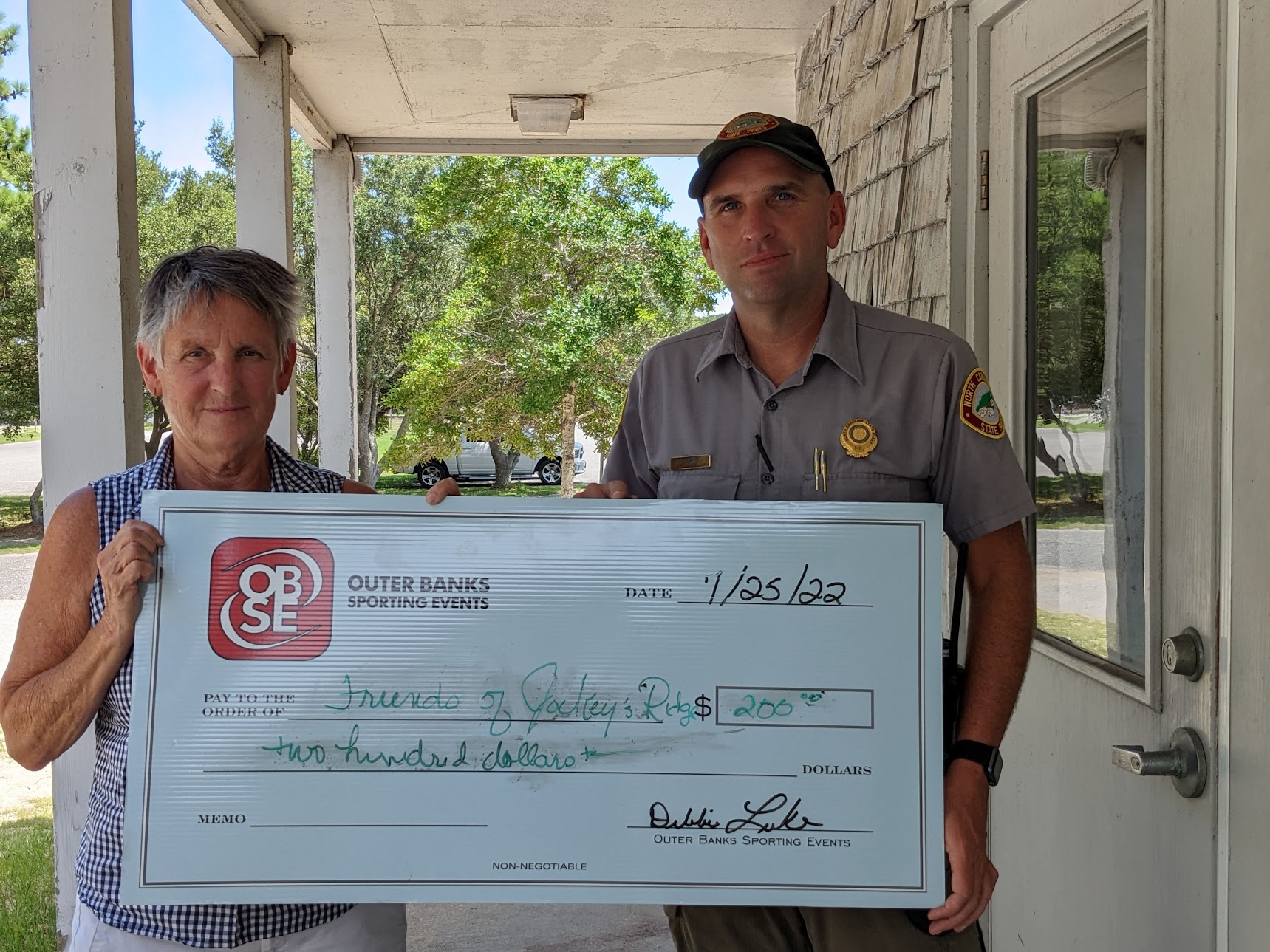 Outer Banks Sporting Events presents check to OBX Repeaters for efforts during Flying Pirate Half Marathon